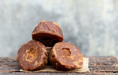 Khejur Gur or Date Palm Jaggery Heap Isolated on Wooden Background with Copy Space