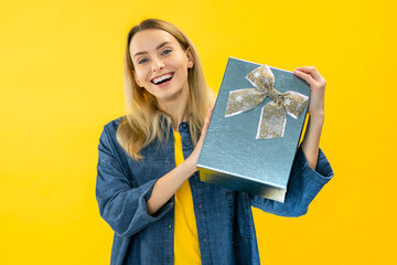 Young woman of caucasian ethnicity hold present box with gift ribbon bow look at camera isolated on...