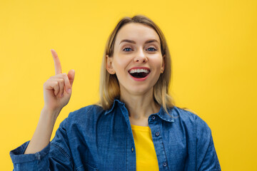 Excited Positive young woman raising finger up and smiling, having wow creative idea or Solution...