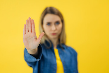 serious woman standing with outstretched hand showing stop gesture