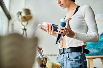 A woman stylishly holds a palette in her hand.