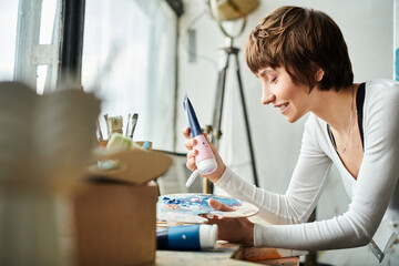 A woman painting a picture on a table.