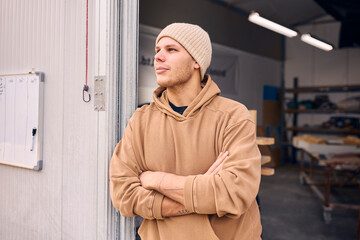 Portrait Of Male Worker Standing In Doorway Of Concrete Workshop 