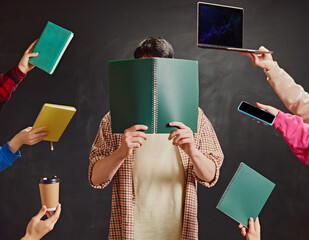 Creative image depicting young male student covering face with notebook, multiple hands with books,...
