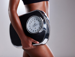 Closeup, fitness and woman with scale, balance and weight loss on white studio background....