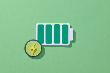 Green energy battery in full charged on a green background