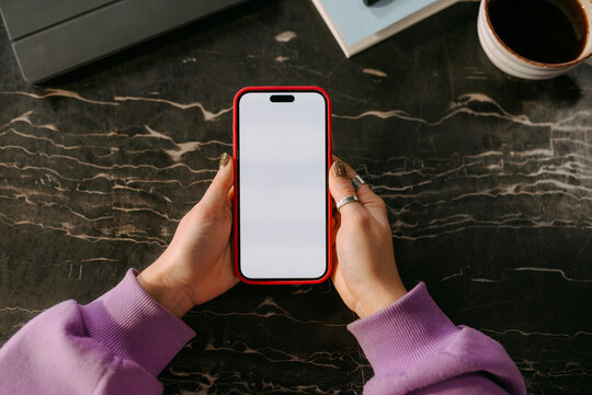 A mobile phone with white screen in a woman's hands