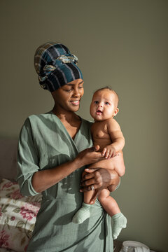 Happy black mother holding naked baby
