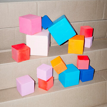 Colourful geometric cubes on a cardboard with hard direct flashlight