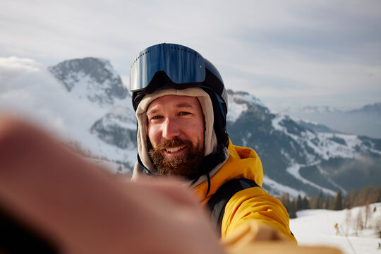 Portrait of a smiling skier taking a selfie