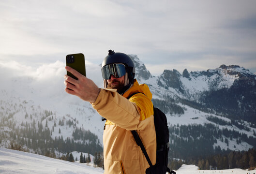 Portrait of a geared up skier taking a selfie