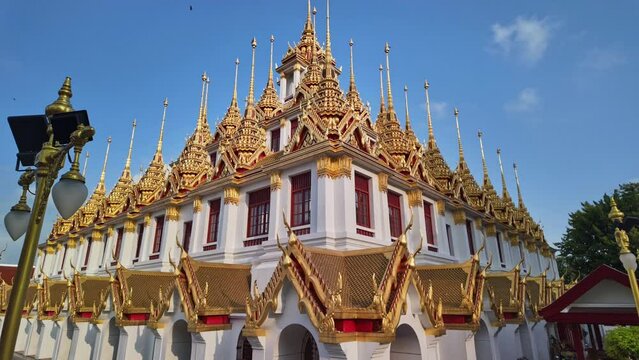 Time lapse scenery The metallic castle covered with gold leaf at of Ratchanatdaram Worawihan.
The Golden castle with spire at Wat Loha Prasat.amazing building with an iron roof made of 37 spires