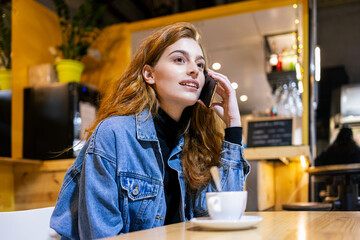 Young red-haired girl talking on her cell phone