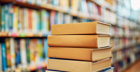 Stack of books on a wooden table.