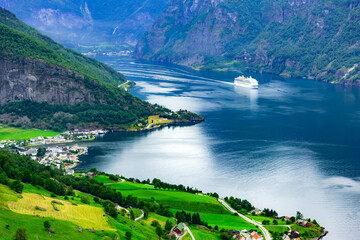 A grand cruise ship sails through Sunnylvsfjorden fjord close to the village of Geiranger in...