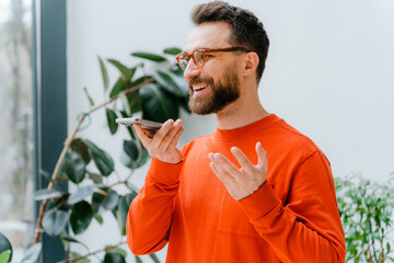 A man records a voice message on a mobile phone