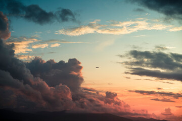 Flying plane during striking cloud sunset