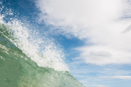 Sunny sea wave with water drops in the air