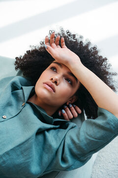 Serenity Interrupted: A Pensive Woman Finds Solace on the Ground