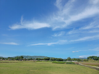 A clear blue sky with a few clouds. The sky is very bright and the sun is shining