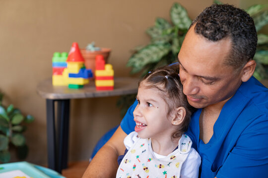 Man physiatrist sitting with happy girl child