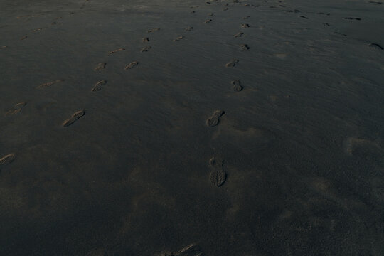 Man footprints on Black sand beach