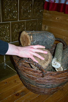 A young man takes a log to fire the stove