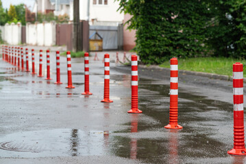 Road sign flexible plastic bollards with pedestrian white marking line and arrow sign on cement...