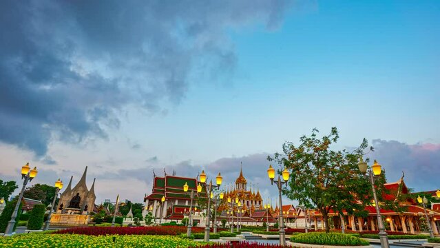 Time lapse beautiful garden in front Loha Prasat,Wat Ratchanatdaram Worawihan. beautiful The spears of the golden castle building with an iron roof. scenery white cloud in blue sky above Loha Prasat