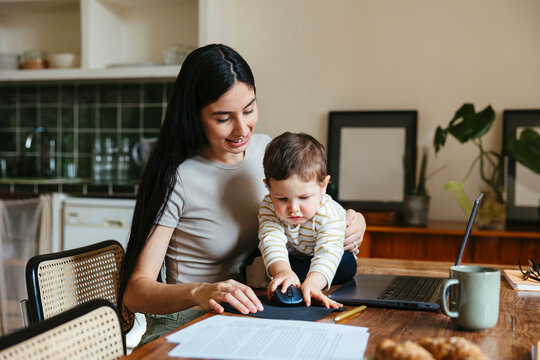 Mother teleworking and taking care her son at home
