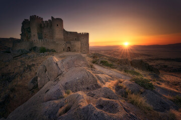 Sunset from the Manqueospese mountain castle, in Mironcillo, Avila, with the sun on the horizon and...