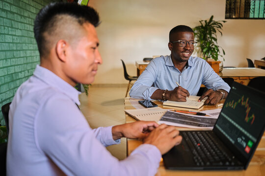 Happy Latino investor friends at work