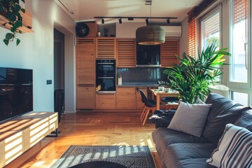 A modern living room with a large plant in the corner. The room has a wooden floor and a wooden kitchen with a stove and oven