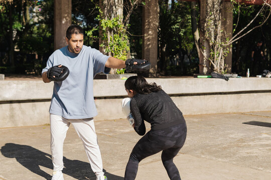 Woman training boxing with her coach.