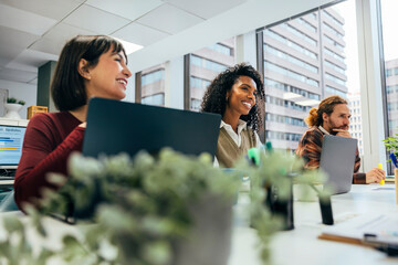 Diverse team smiling and working in modern office