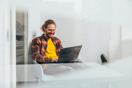 Casual businessman working on laptop in modern office