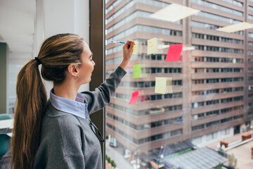 Young professional organizing tasks with sticky notes
