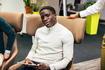 Young black man seated in a modern office lounge