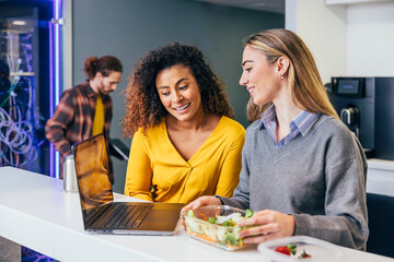 Colleagues sharing a meal in a modern office kitchen