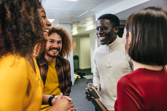 Diverse team engaging in a cheerful conversation at office
