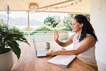 Smiling woman in stylish wear having chat on laptop