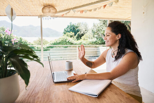 Smiling woman in stylish wear having chat on laptop
