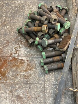 Rejected and rusted nut bolt lying on  floor