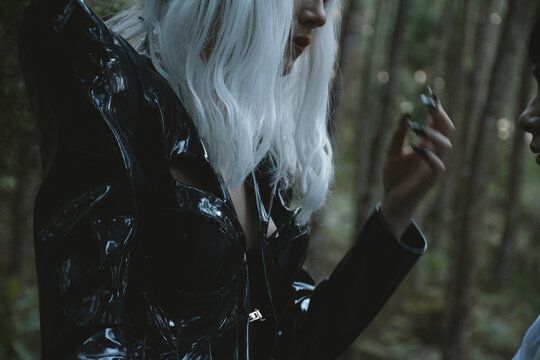Futuristic Woman  in Black Costume  with White Wig in a Forest  Sunset