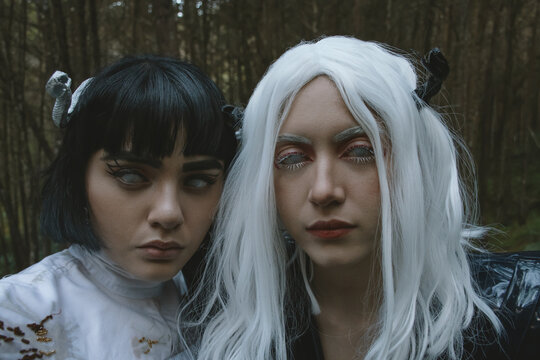 Women in costumes posing in. green forest 