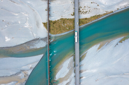 Topdown of a truck crossing a bridge over a braided river