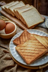 Morning breakfast three slice of Toasted bread on white plate with wooden blackground ,  home cooked