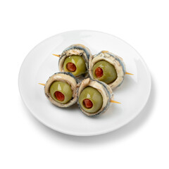 Plate with Spanish tapas, pair of green olives stuffed with red pepper and anchovy isolated on white background