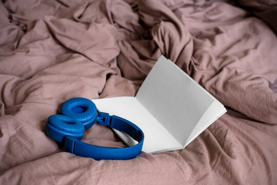 Headphone and notepad on a bed