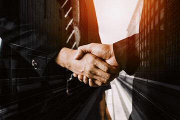 Double exposure image of business people handshake on city office building in background showing...